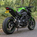 Generated concept image of a Kawasaki Z900 with a compact tail tidy and WingAero FlipIT plate, outdoor rear three-quarter view