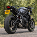 Triumph Street Triple with WingAero FlipIt electric flip plate bracket in an outdoor setting, rear three-quarter view